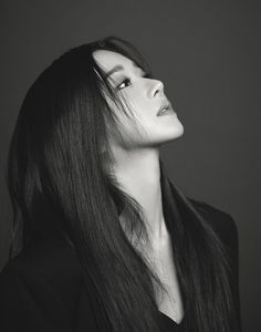 a black and white photo of a woman with long hair looking off to the side