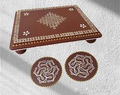 a brown table with two matching chocolates on it and an intricately decorated tray