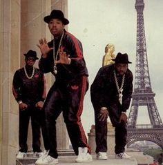 the three men are posing in front of the eiffel tower