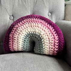 a crocheted pillow sitting on top of a gray couch