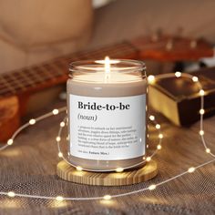 a candle sitting on top of a table next to a string of lights and a guitar