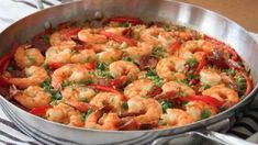 a pan filled with shrimp and vegetables on top of a table