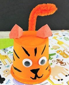 a paper cup with a tiger face on it and an orange tube sticking out of the top