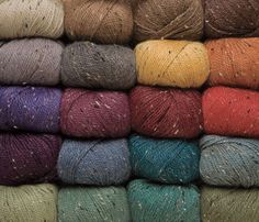 several skeins of multicolored yarn are stacked on top of each other