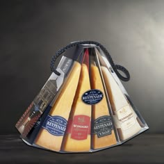 a triangle shaped cheese basket with different types of cheese in it and labels on the sides