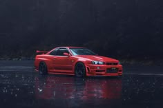 the red car is parked on the wet road