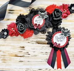 three red, black and white flowers are on top of each other with ribbons around them