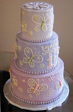 a three tiered cake with butterflies on it