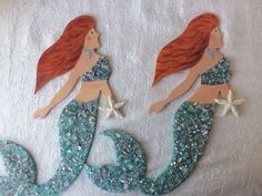 two little mermaids made out of plastic and glitter