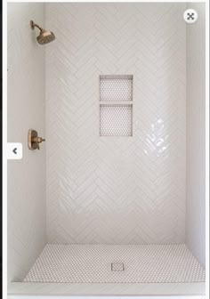 a bathroom with white tile and gold fixtures on the shower head is shown in this image