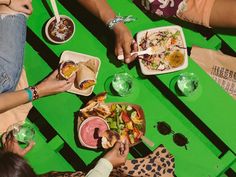 several people sitting at a table eating food