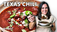 a woman is holding a spoon over a bowl of chili and green peppers with the words texas chili above her