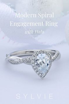 an engagement ring with a pear shaped diamond in the center and side stones on each band