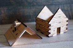 two small wooden houses sitting on top of a table