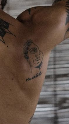 the back of a man with tattoos on his chest