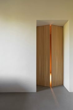 an open wooden door in a white room