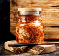 a jar filled with food sitting on top of a wooden board