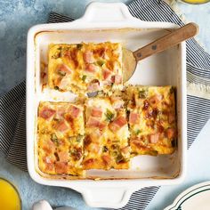 a casserole dish with ham, cheese and broccoli in it on a blue table cloth