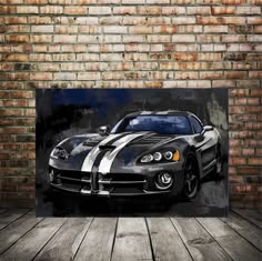 a painting of a sports car on a wooden floor in front of a brick wall