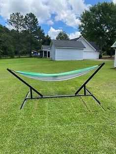 a hammock sitting on top of a metal stand in the middle of a field