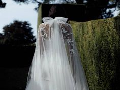 the back of a woman's wedding dress, with long sleeves and lace on it