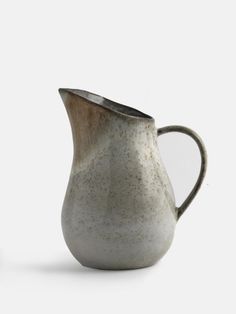 a white and brown pitcher sitting on top of a table