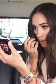 a woman is talking on her cell phone while in the back seat of a car