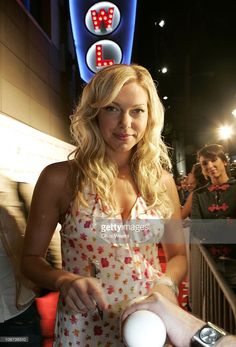 a woman standing in front of a crowd holding a white frisbee