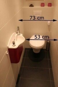 a bathroom with a toilet, sink and measurements for the size of the space in front of it