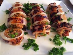 some food is laying out on a white plate with green garnish and parsley