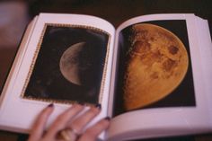 an open book with a picture of the moon and mars in it's pages