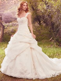 a woman in a white wedding dress posing for a photo with her hand on her hip