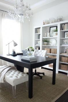 a black table with white chairs and a chandelier