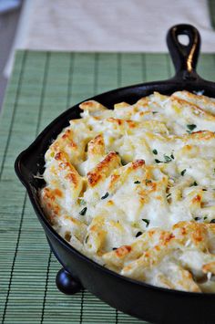 a casserole dish with cheese and parsley in a cast iron skillet