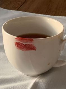 a white cup filled with liquid on top of a table