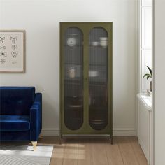 a living room with a blue chair and green cabinet