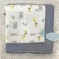 a baby blanket with giraffes on it and a pacifier next to it