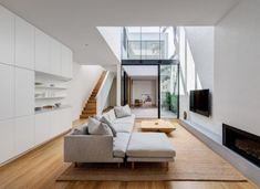 a modern living room with white walls and wood flooring is seen in this image