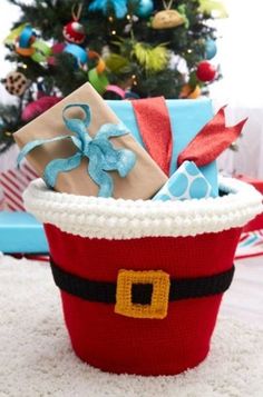 a christmas basket with presents in front of a tree