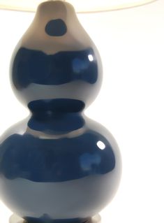 a blue and white vase sitting on top of a table next to a lampshade