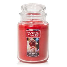 yankee candle jar with an apple on the lid and red wax in front of it