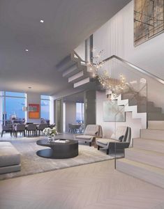 a living room filled with lots of furniture and a staircase leading up to the top floor