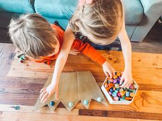 two children are playing with candy on the floor