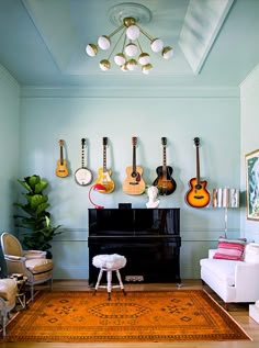 a living room with guitars on the wall and a piano in the corner next to it