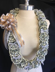 a white mannequin wearing a necklace made out of dollar bills with a bow