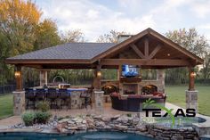 an outdoor living area with a pool, grill and bar in the middle of it