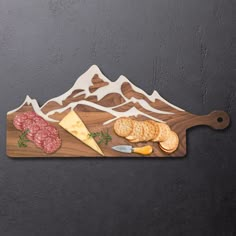 a cutting board with cheese, meat and crackers on it