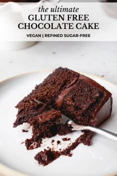 the ultimate gluten free chocolate cake is on a plate with a fork in it