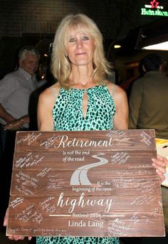 a woman holding a sign that says retirement is the most important part of the road