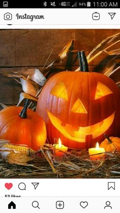 two pumpkins sitting on top of hay next to each other with candles in them